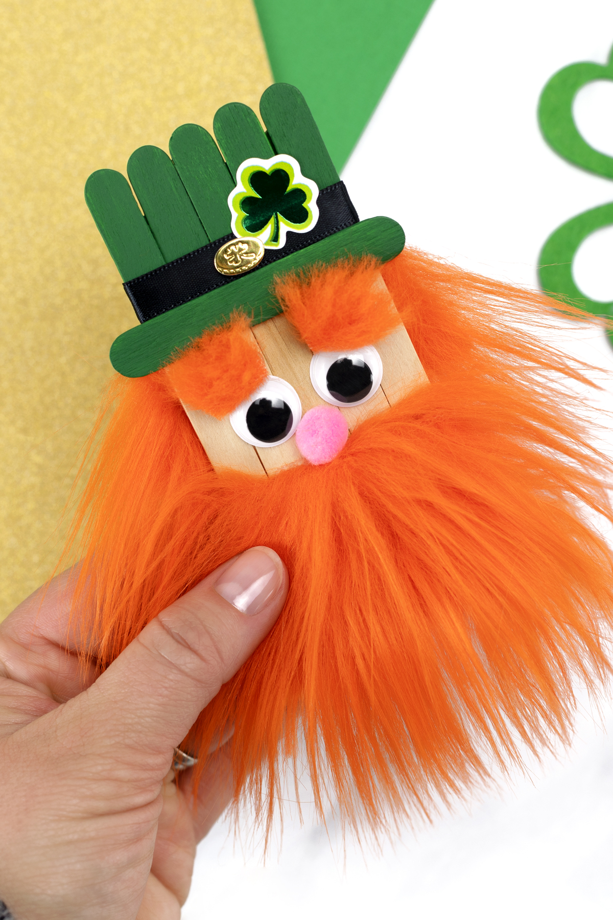 A leprechaun figure assembled from popsicle sticks and decorated with paper and markers.