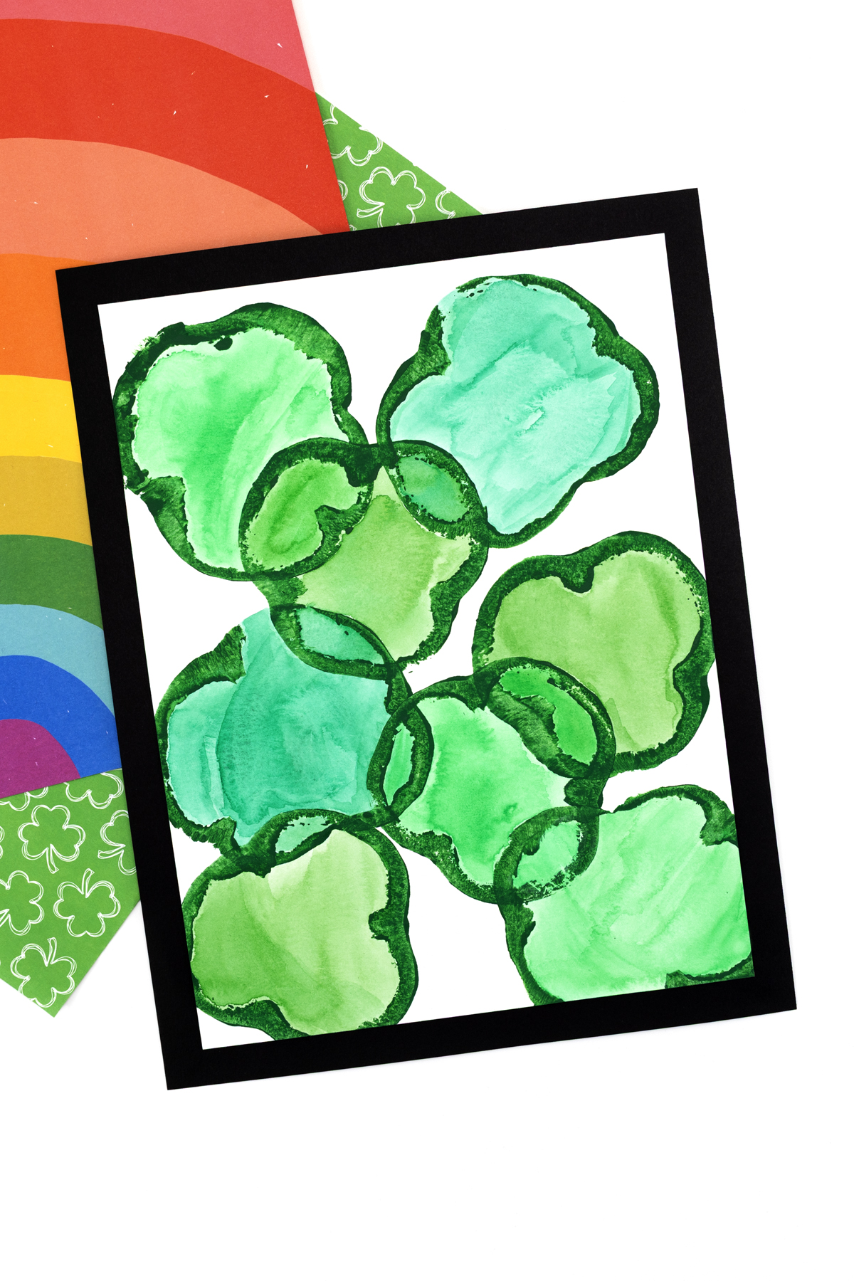 Close-up of green pepper shamrock prints colored with watercolors and mounted on green construction paper.