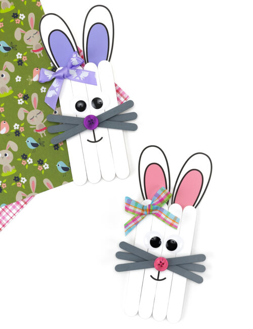 Finished popsicle stick bunny craft examples with different decorations and facial details.