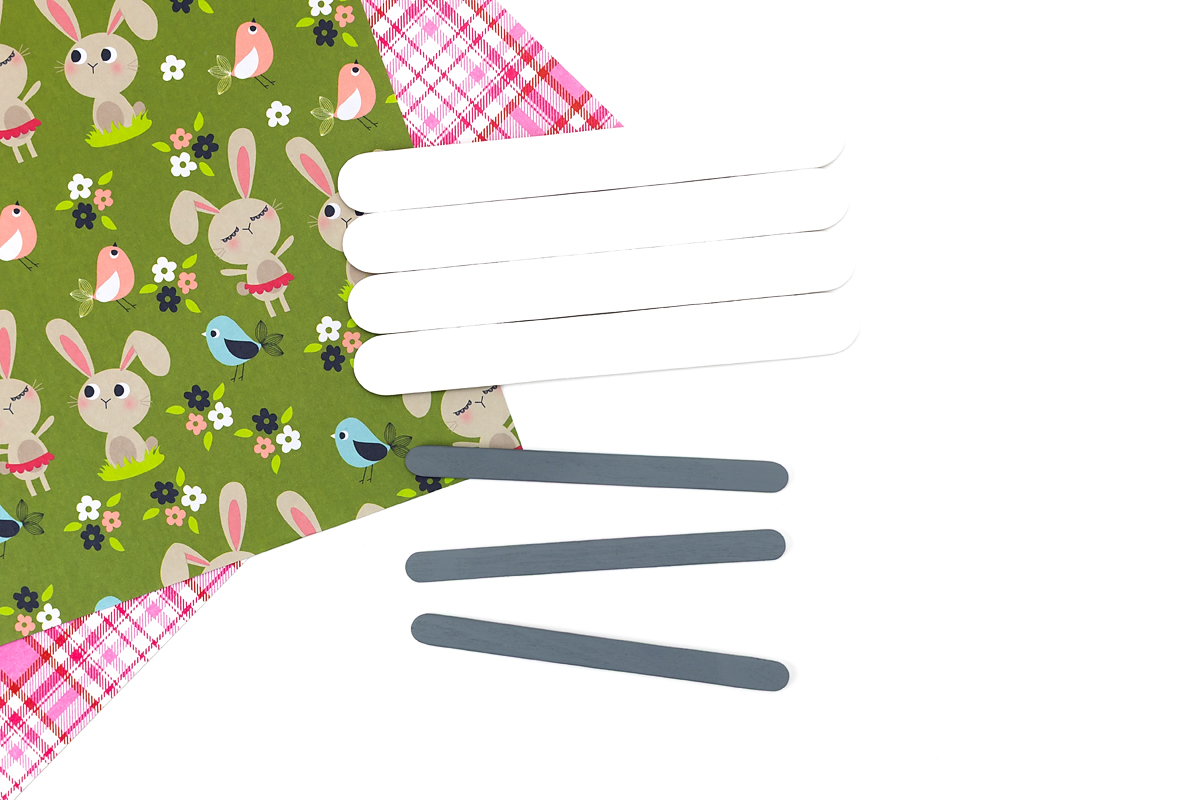 Painting wide popsicle sticks white and standard sticks gray for a popsicle stick bunny craft.