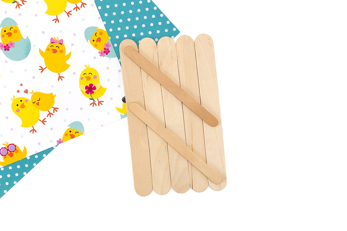 Five wide popsicle sticks glued together with two smaller sticks across the back to form the chick’s body panel.