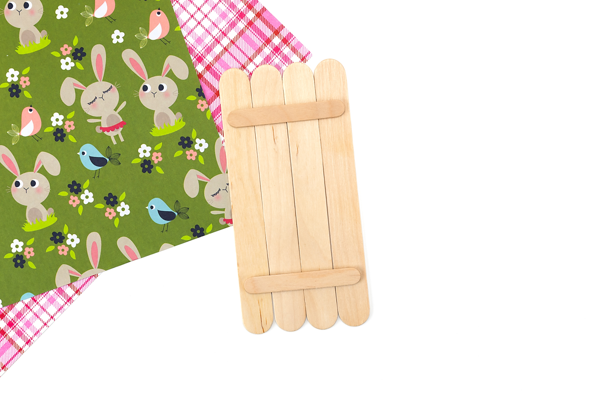 Four wide popsicle sticks glued together with mini sticks on the back to form a bunny face base.