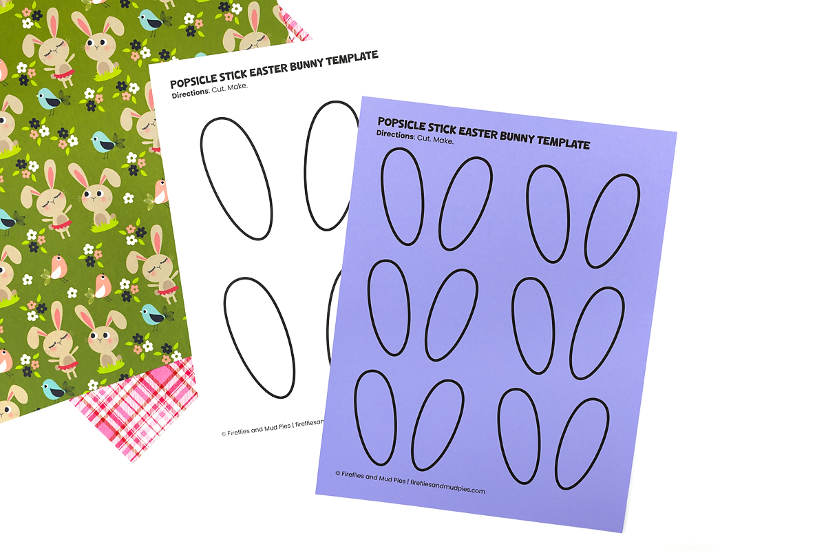 Cutting out bunny ears, eyes, and mouth from a printed template for a popsicle stick bunny craft.