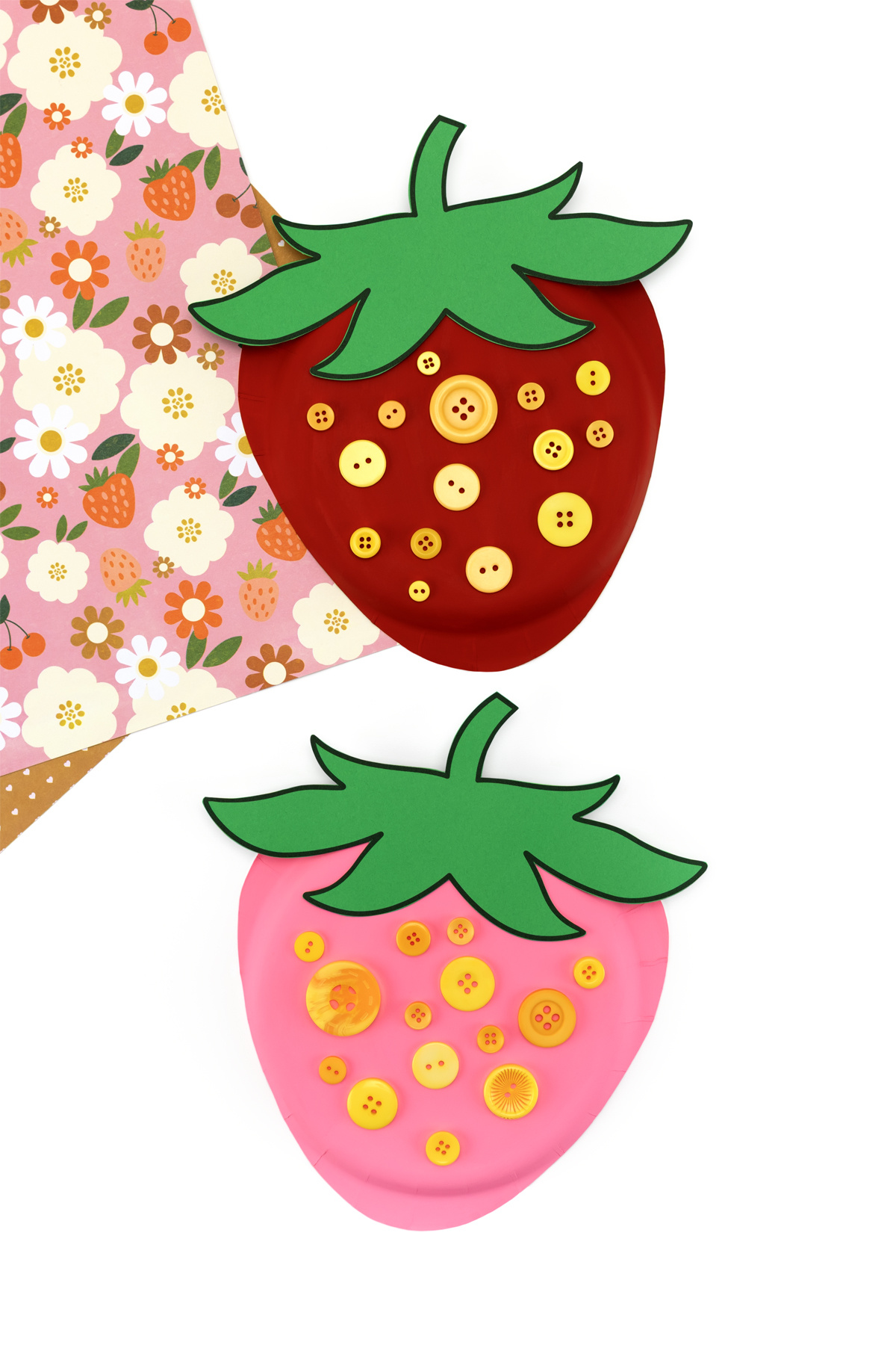Bright red and pink paper plate strawberry craft displayed on a plain background.