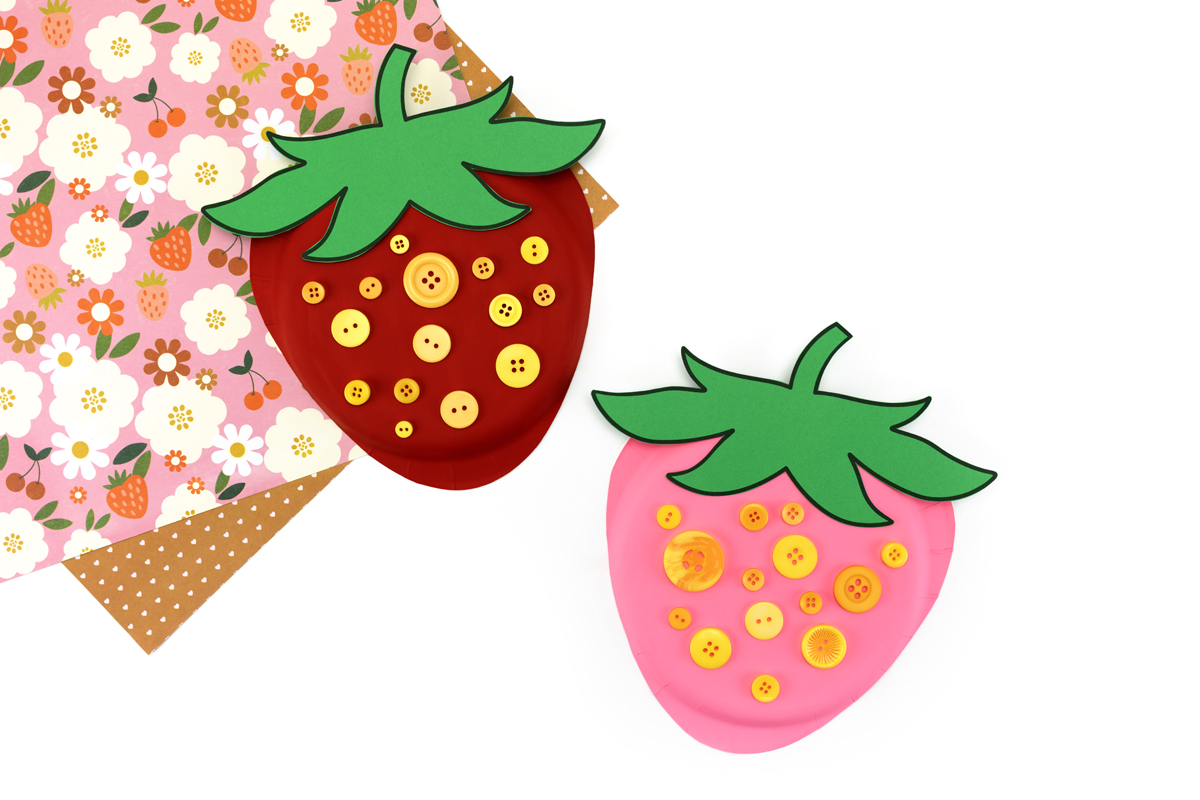 Group of paper plate strawberry crafts arranged together for a colorful summer display.