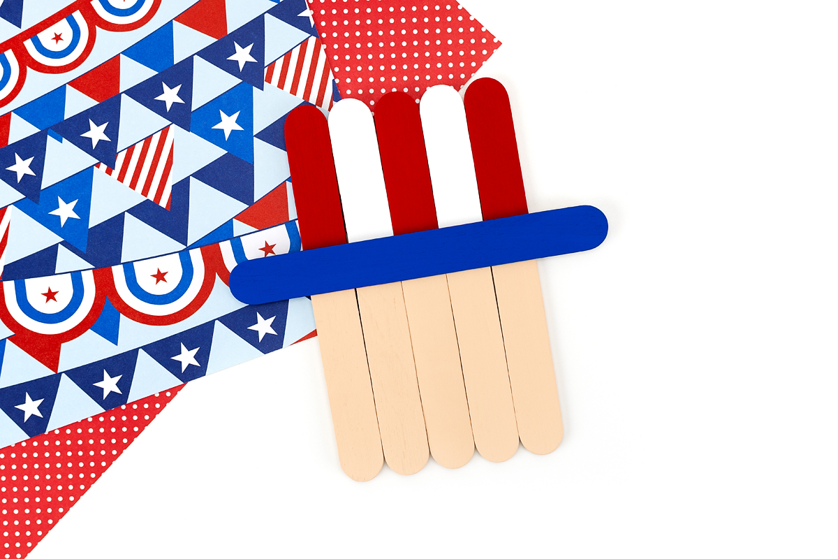 Popsicle sticks painted red and white with a blue craft stick hat brim for an Uncle Sam craft.
