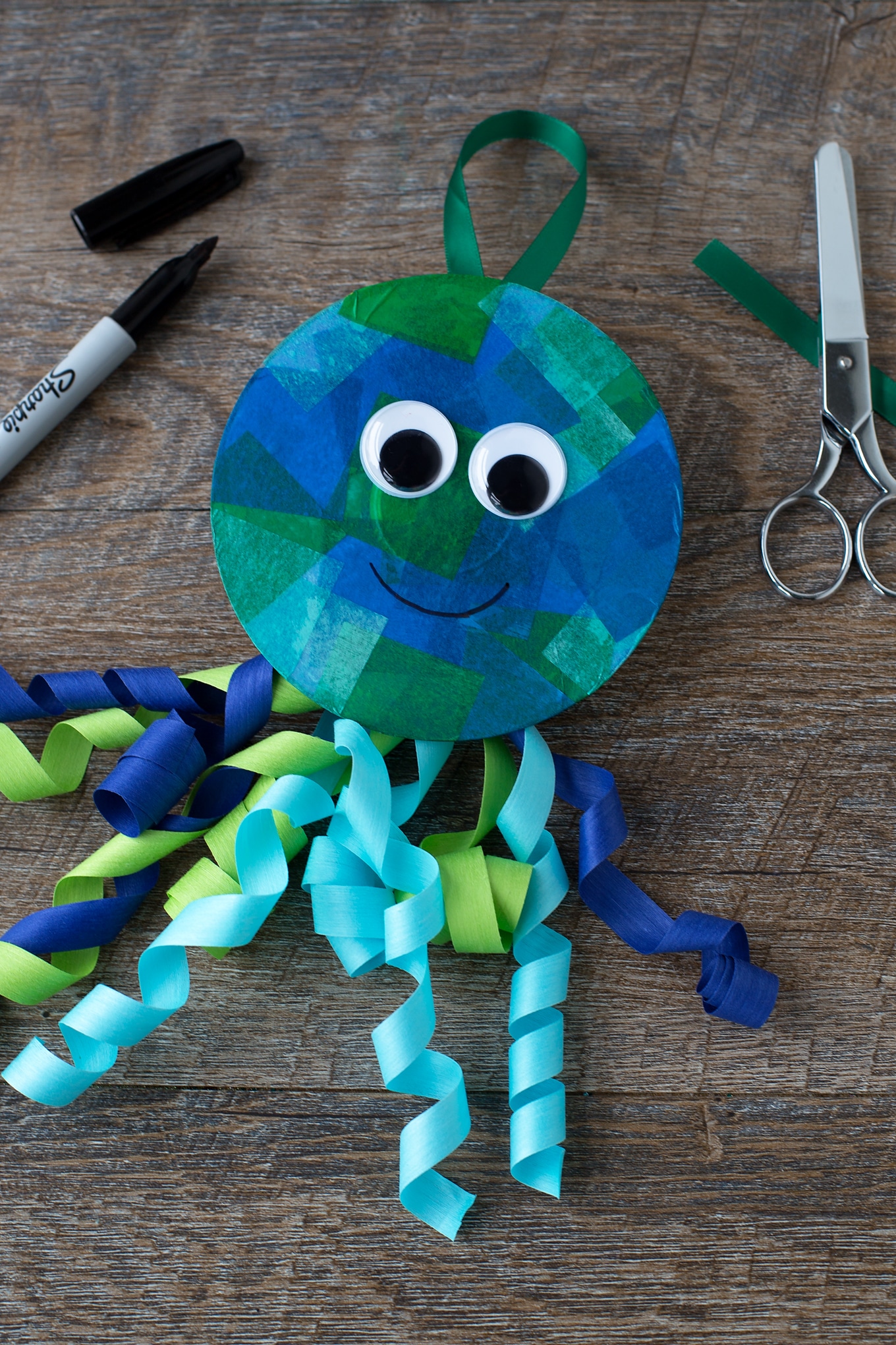 Summer is the perfect season for creating ocean-themed art. Learn how to make a colorful upcycled CD and ribbon jellyfish craft. #jellyfishcrafts #summercrafts #oceancrafts #animalcrafts #kidscrafts Blue Jellyfish Craft