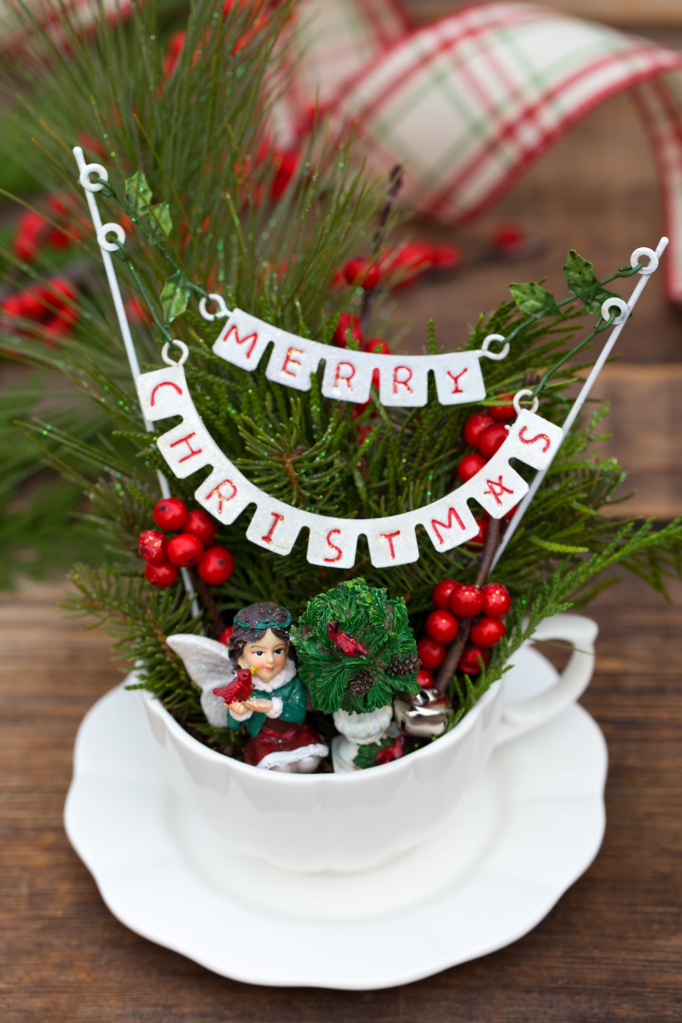 Just in time for Christmas, learn how to make a festive Christmas Teacup Garden with pine sprigs, winterberry, a teacup and saucer, and Christmas miniatures. #diychristmasgift #christmascrafts #teacupgarden #fairygardencrafts #christmasteacupgarden How to Make an Adorable Christmas Teacup Garden