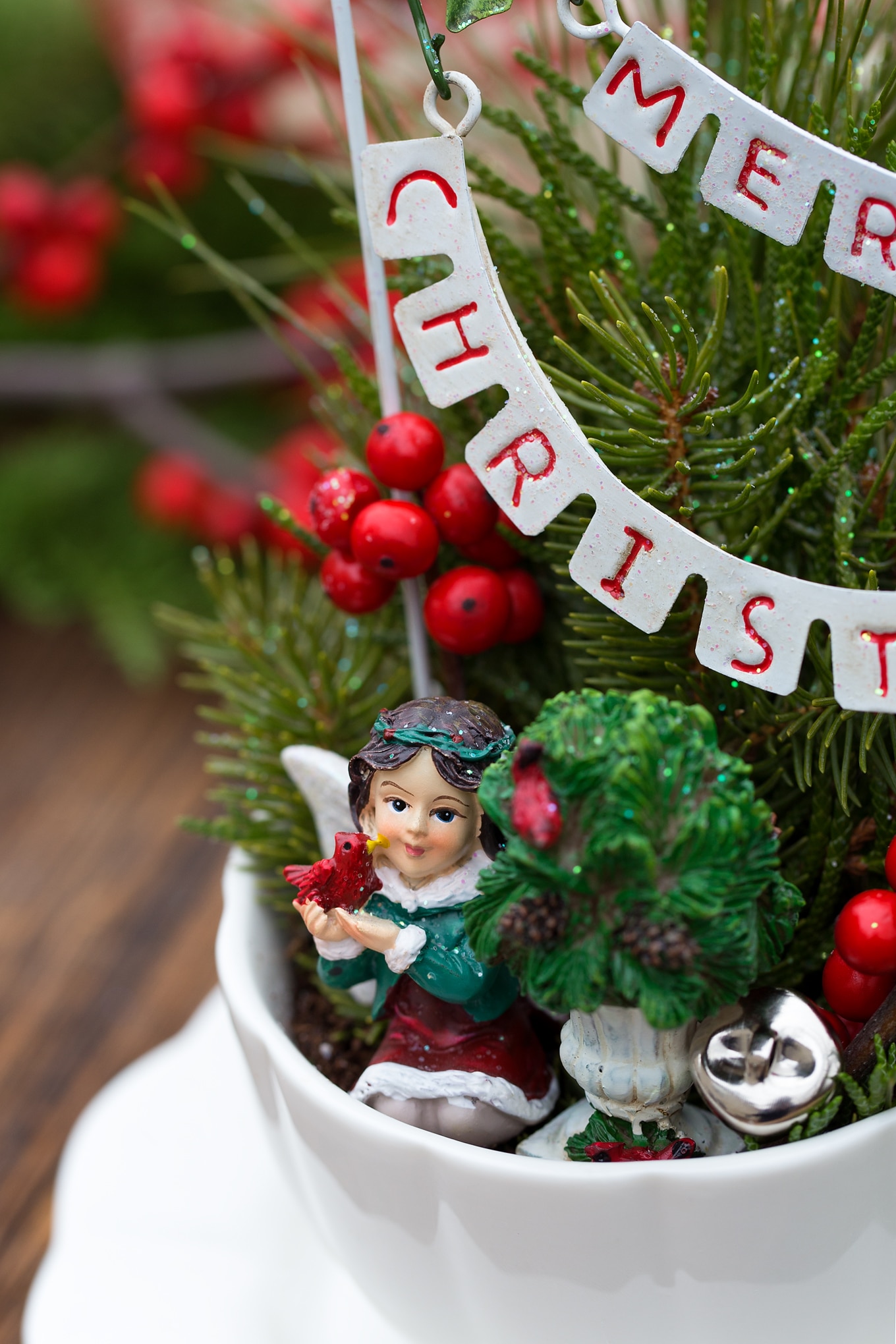 Just in time for Christmas, learn how to make a festive Christmas Teacup Garden with pine sprigs, winterberry, a teacup and saucer, and Christmas miniatures. #diychristmasgift #christmascrafts #teacupgarden #fairygardencrafts #christmasteacupgarden Christmas Fairy in DIY Teacup Garden