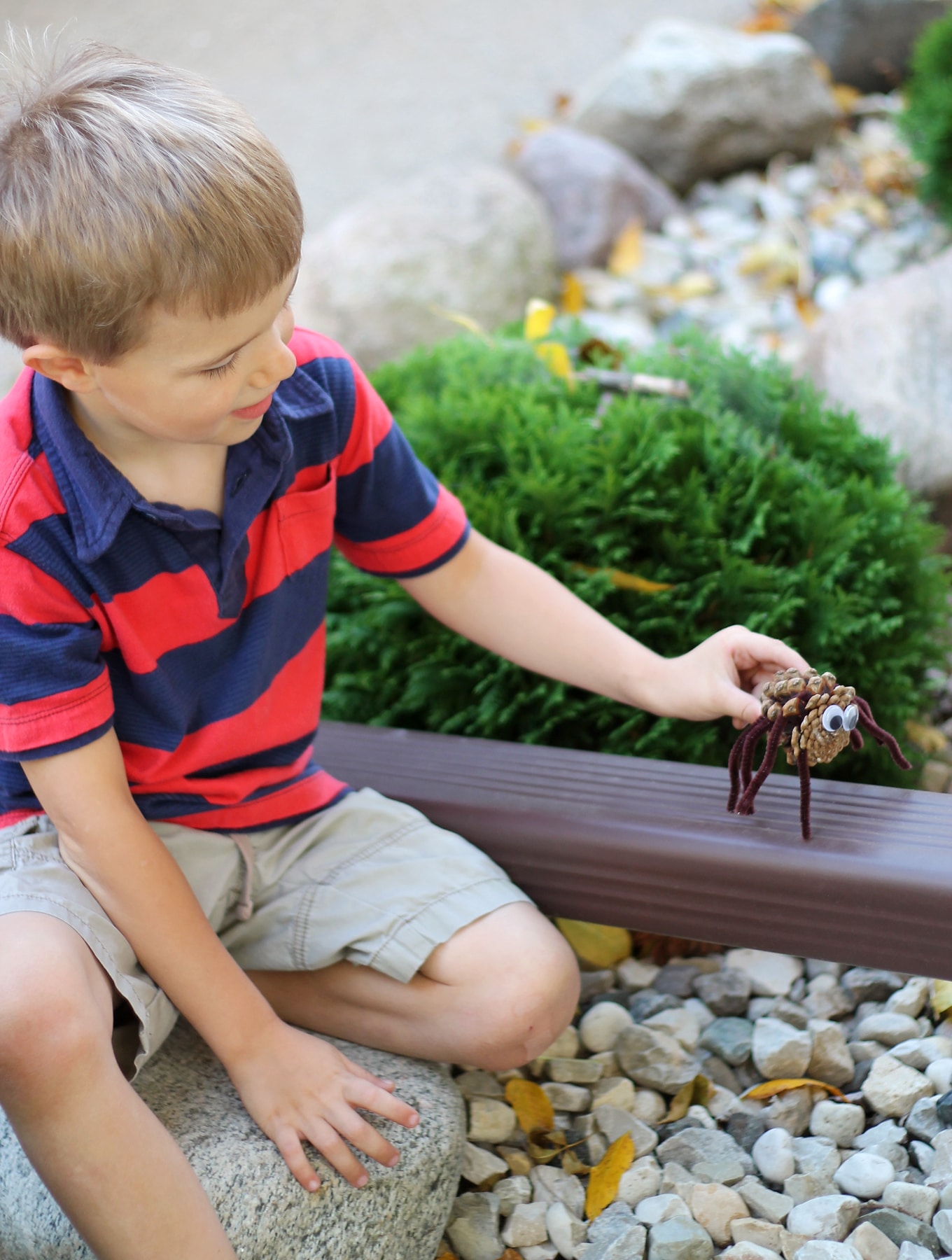 Child Playing with Pine Cone Spider Craft Child Playing with Pine Cone Spider Craft