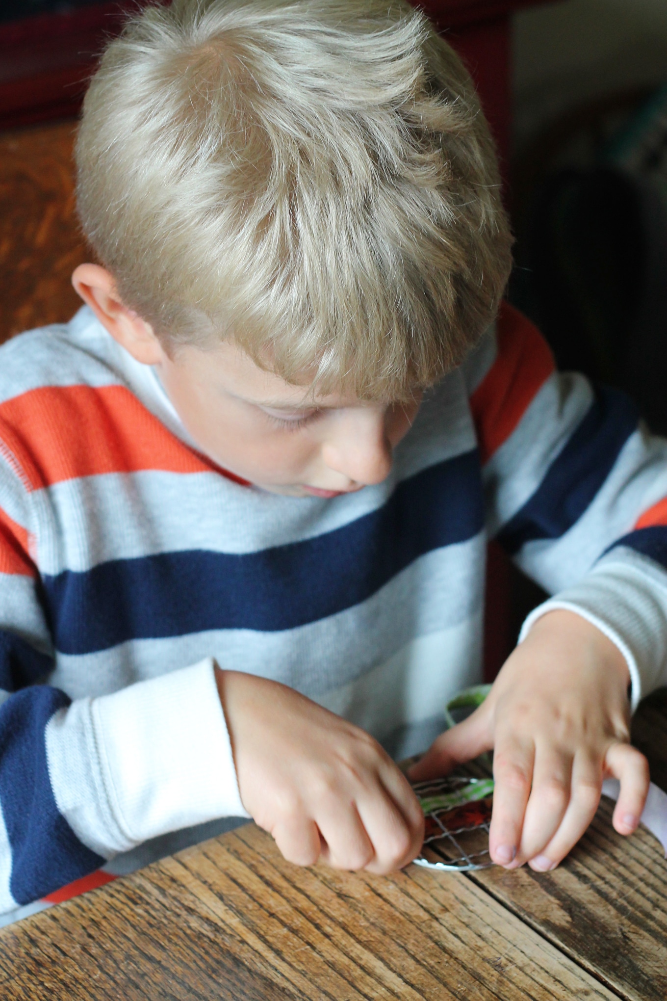 Just in time for fall, learn how to make vibrant pumpkin suncatchers with scraps of woven ribbon and mason jar lids. This weaving craft is perfect for kids!
