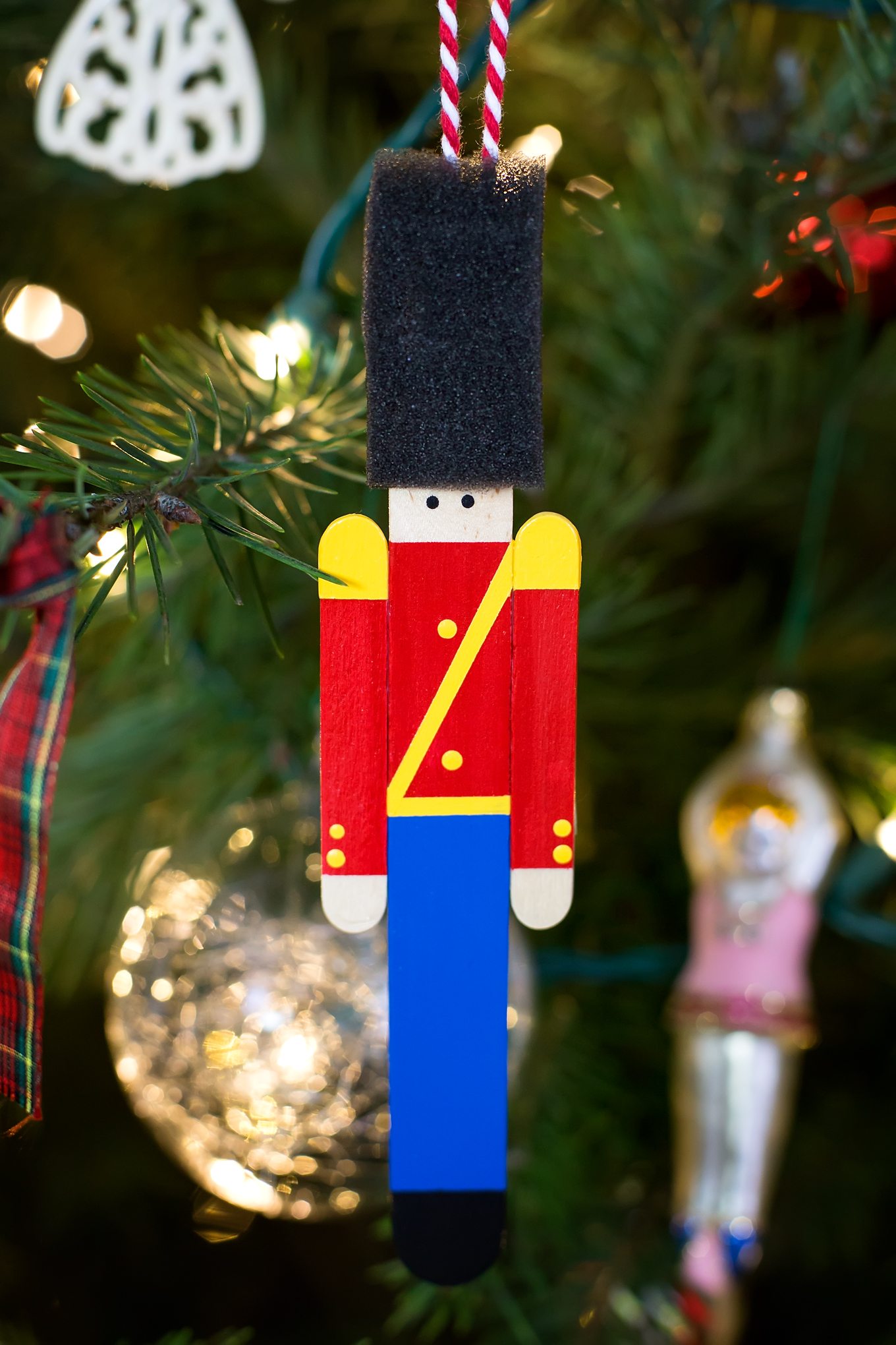 Crafters big and small will delight in making a Wooden Toy Soldier Ornament with craft sticks, paint, and one extra unique craft material. 